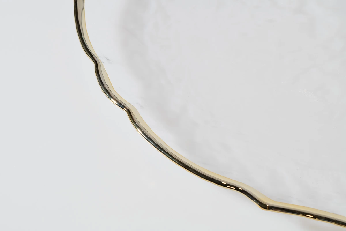 צילום צלחת הגשה דקורטיבית עם שולי זהב, צילום תקריב מסטודיו לצילום מוצרי יוקרה. עיצוב אלגנטי ויוקרתי.